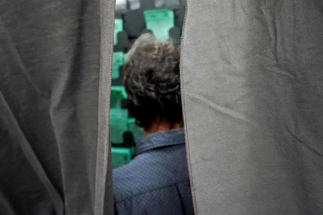 Un ciudadano elige  una  papeleta para ejercer su derecho al voto durante el día de las elecciones a la presidencia de la Junta de Andalucía  a 19 de junio de 2022 en Sevilla (Andalucía, España).