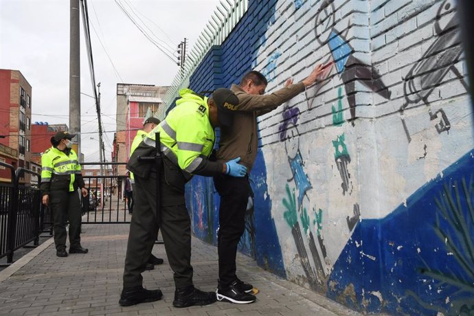 Agentes de la Policía registran a un individuo en Bogotá, Colombia