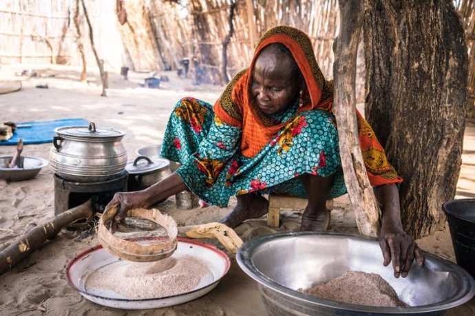 Archivo - Una mujer africana prepara una comida en su cocina rural