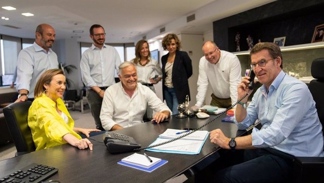 El lider del PP, Alberto Núñez Feijóo, conversa con Juanma Moreno desde la sede nacional del PP rodeado de su equipo. En Madrid, 19 de junio de 2022.