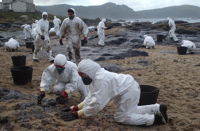 Archivo - Costas y playas coruñesas bañadas por vertido de fuel que derramó el Prestige, voluntarios ayundando a limpiar el vertido.