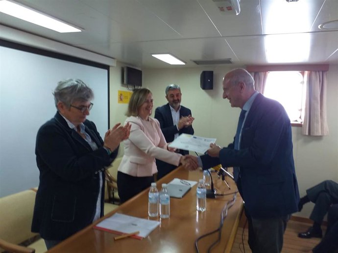 La directora general de Pesca Sostenible de España, María Isabel Artime, hace entrega de un diploma al director del Centro de Seguridad Marítima Integral Jovellanos de Gijón, Indalecio Estrada, en un acto en el buque 'Intermares', en El Miusel (Gijón)