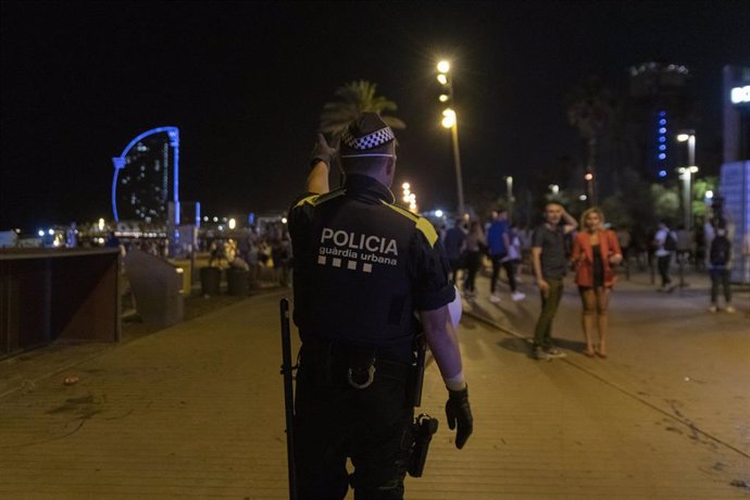 Archivo - Un agente de la Guardia Urbana en las inmediaciones de la playa de la Barceloneta, en una imagen de archivo.