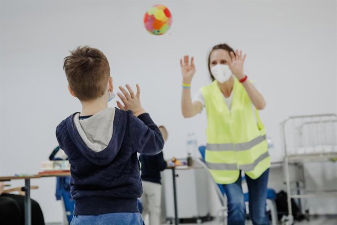Archivo - Un niño refugiado ucraniano juega a la pelota con una trabajadora en el Hospital Isabel Zendal.