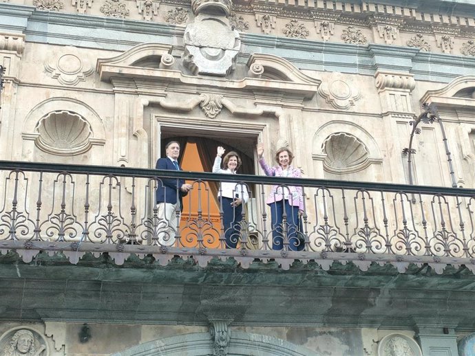 La Reina Sofía (derecha) y la Reina Silvia de Suecia (centro) saludan desde el balcón del Ayuntamiento de Salamanca junto al alcalde de la ciudad, Carlos García Carbayo (izq)