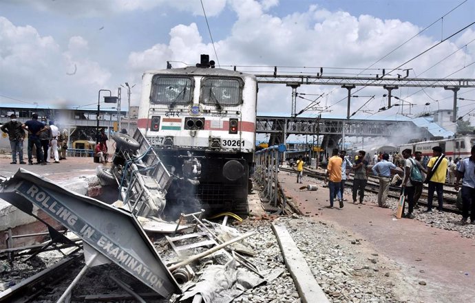 Un tren con graves daños durante las protestas contra la nueva ley de reclutamiento en India