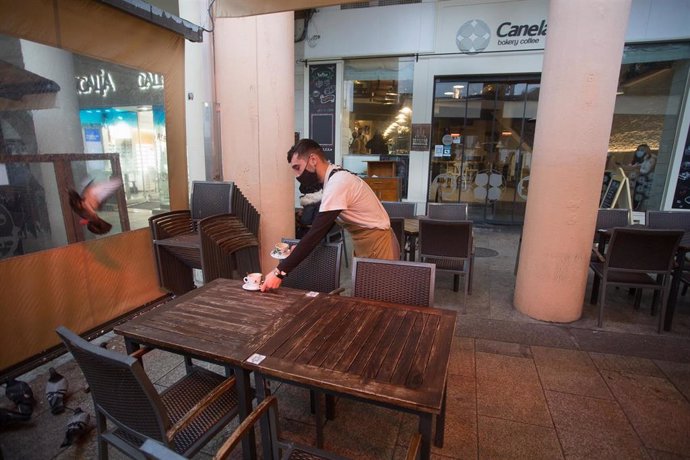 Archivo - Un camareiro recolle a mesa dunha terraza o primeiro día do peche perimetral decretado en Lugo, Galicia (España), a 15 de xaneiro de 2021. O peche perimetral forma parte do paquete de novas restricións da Xunta para frear a expansión do virus e