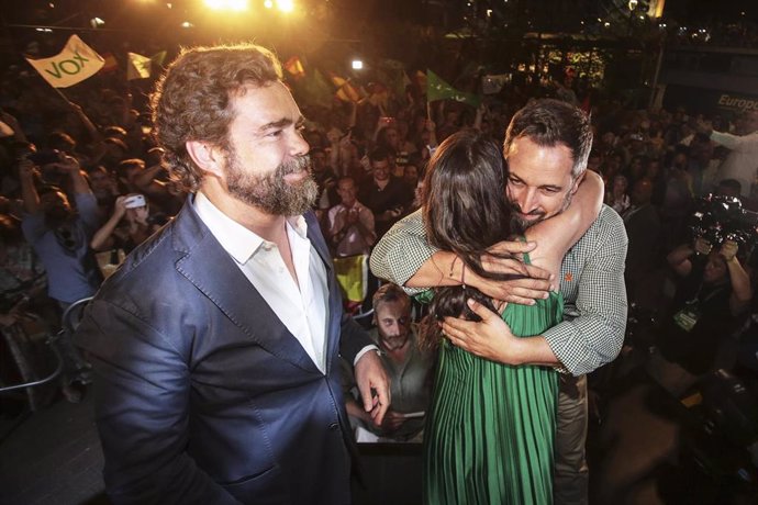 El prtavoz de Vox en el Congreso, Iván Espinosa de los Monteros, en la noche electoral de Andalucía mientras se abrazan el presidente del partido, Santiago Abascal, y su candidata, Macarena Olona