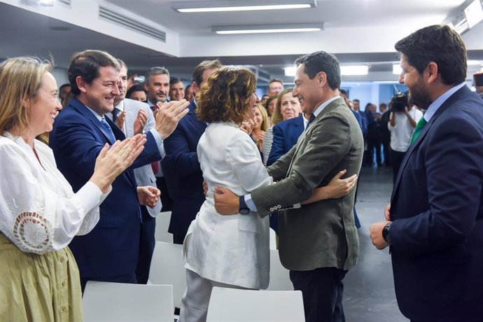 La presidenta de la Comunidad de Madrid, Isabel Díaz Ayuso (i), abraza al presidente del PP andaluz y presidente electo de la Junta de Andalucía, Juanma Moreno (d), a su llegada a una reunión de la Junta Directiva Nacional del PP, en la sede del PP, a 2