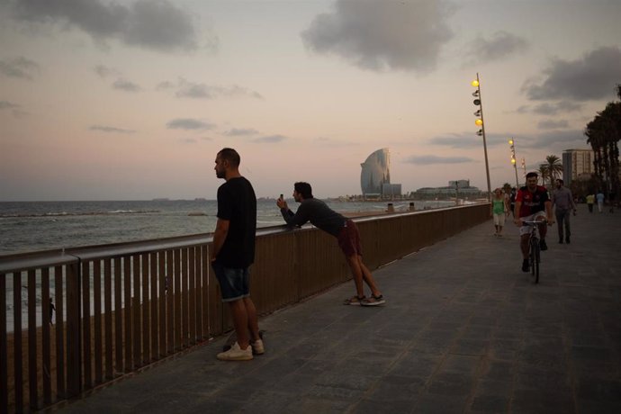 Archivo - Dos hombres miran el paisaje frente a la playa de la Barceloneta, en Barcelona, Catalunya (España).