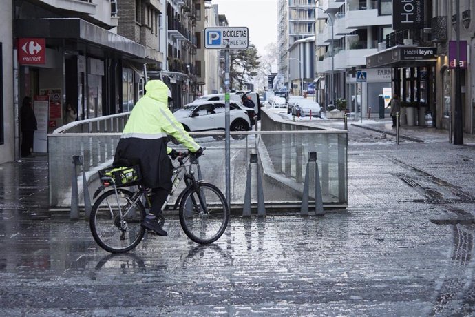 Archivo - Una persona en bicicleta sobre la nieve derretida en Pamplona (archivo)