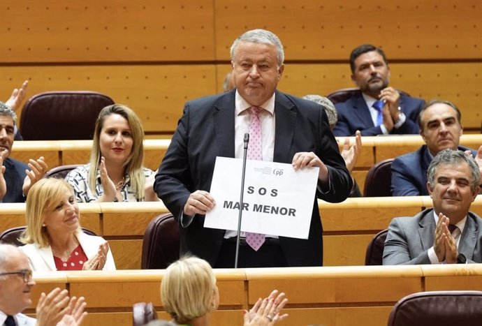 El senador del PP Francisco Bernabé sostiene una pancarta en la que se puede leer 'S.O.S. Mar Menor'