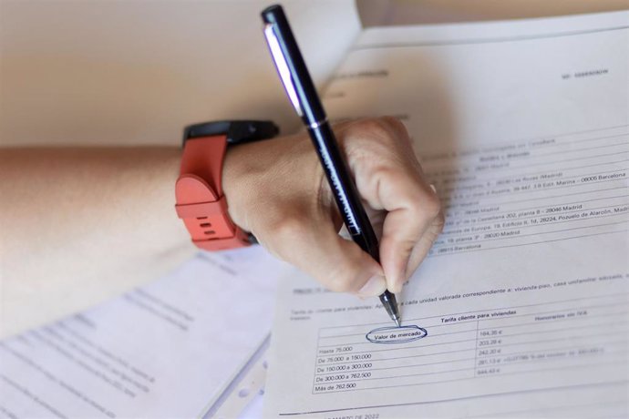 Una mujer señala el valor de mercado de una escritura de compraventa de una hipoteca, a 30 de mayo de 2022, en Madrid (España).