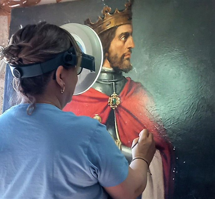La restauradora del Centro de los Oficios de León Elisa Lobato restaura el retrato de Alfonso XI.
