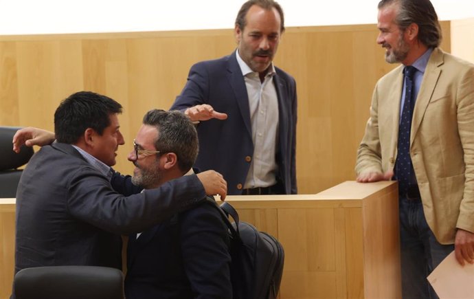 El diputado del PP Francisco Oblaré y el socialista Manuel Chicón se abrazan en el pleno de la Diputación de Málaga, en presencia de los diputados Juan Cassá y Victor González, tras ser elegido el 'popular' como parlamentario andaluz.