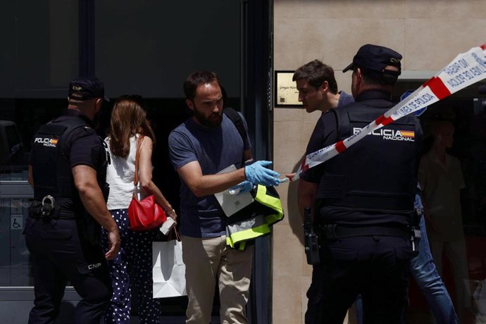 Varios agentes y una mujer pasa al portal de la vivienda de la calle serrano