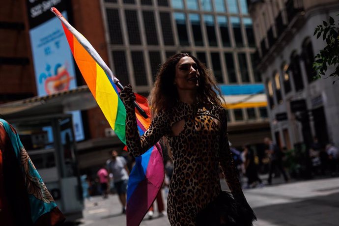 Una mujer con una bandera LGBT.