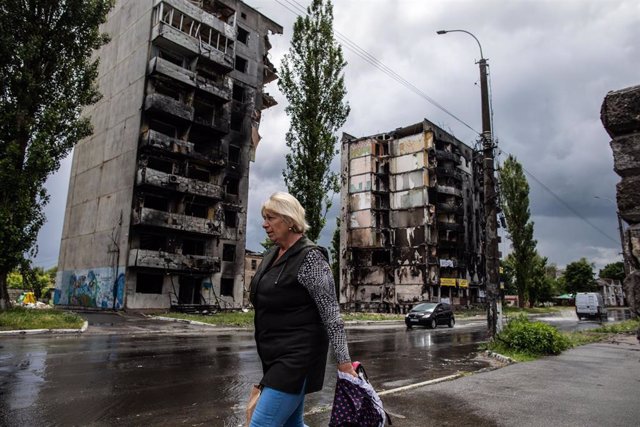 Una mujer camina por una calle con edificios destruidos en la ciudad ucraniana de Borodianka