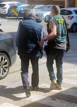Un agente de la Guardia Civil custodia al detenido