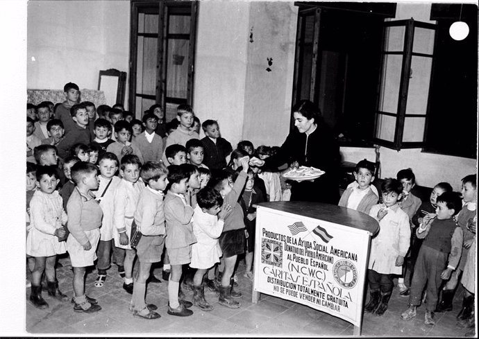 Un grupo de niños recibe productos de la Ayuda Social Americana.