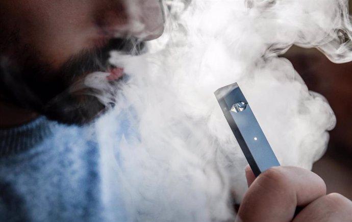 Archivo - FILED - 30 September 2019, North Rhine-Westphalia, Oberhausen: A man uses an e-cigarette made by Juul Lab. The number of deaths from a mysterious lung illness linked to the use of e-cigarettes has risen to 37 in the United States, the Centers 