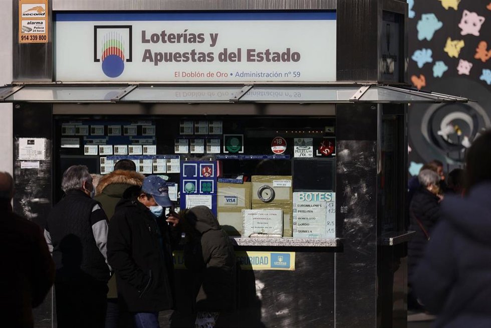 Archivo - Varias personas en las inmediaciones de una administración de loterías (archivo)