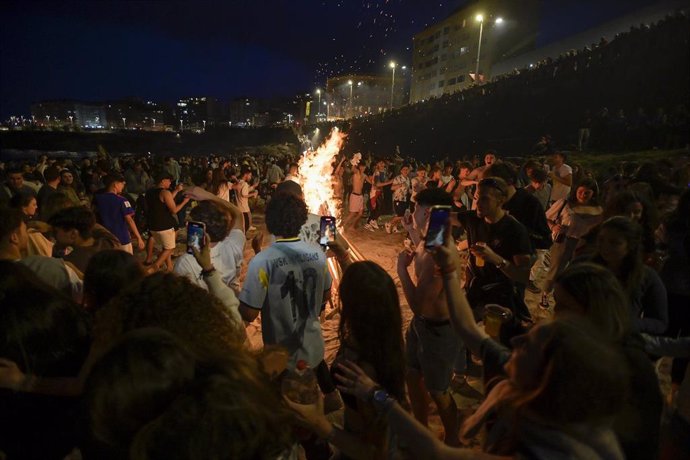 Centenares de persoas fronte a unha fogueira na Noite de San Juan, a 23 de xuño de 2022, na Coruña, Galicia (España). 