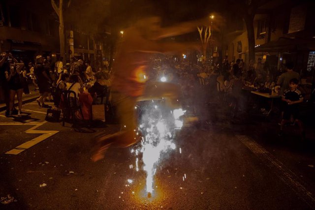 Una persona salta una bengala en la tradicional verbena de Sant Joan, a 23 de junio de 2022, en Barcelona