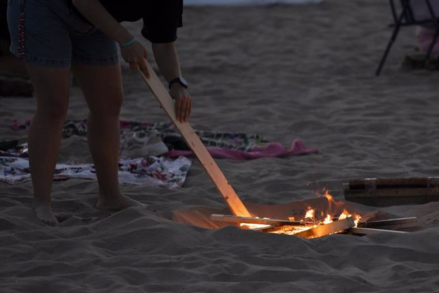 Una persona prepara una hoguera sobre madera en la playa de la Malvarrosa durante la Noche de San Juan, a 23 de junio de 2022, en Valencia, Comunidad Valenciana (España). 