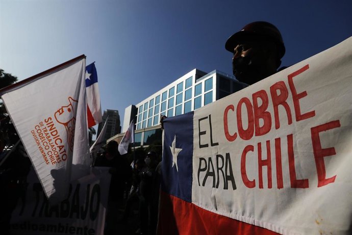 15 June 2022, Chile, Valparaiso: An employee of the Ventana mine of the Codelco group holds a placard reading "Copper for Chile," during a protest in front of the parliament.