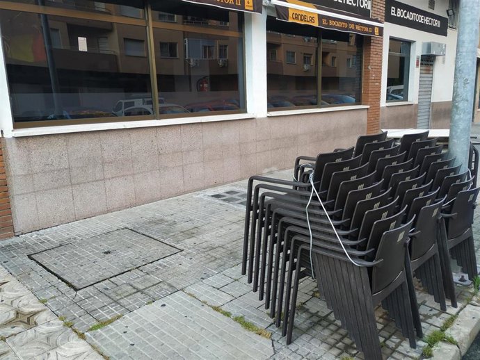 Archivo - Mobiliario de una terraza en Cáceres almacenado en la vía pública en una foto de archivo