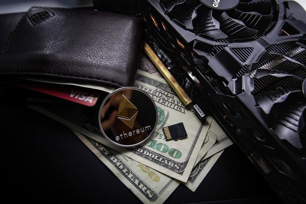 Representación gráfica de una moneda de Ethereum junto a una tarjeta gráfica y una cartera con billetes.