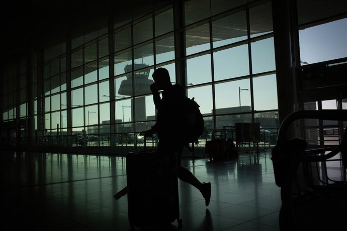 Archivo - Un home camina amb el seu equipatge a l'aeroport de Barcelona-el Prat