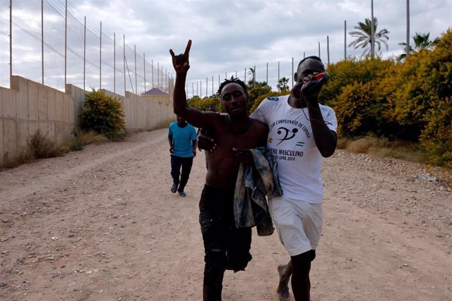 Varios migrantes se dirigen al Centro Temporal de Inmigrantes (CETI), mientras celebran el salto de la valla de Melilla, a 24 de junio de 2022, en Melilla (España).