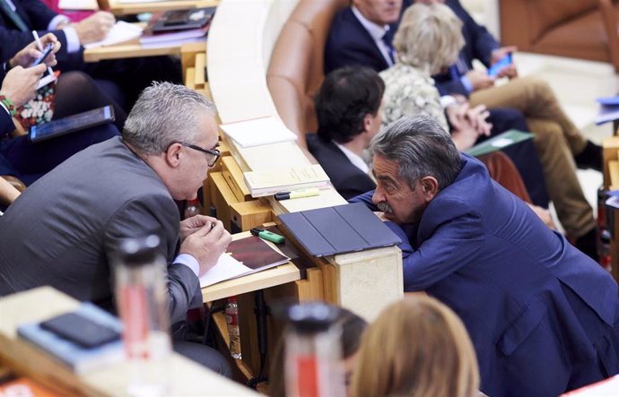 Archivo - El presidente de Cantabria y secretario general del PRC, Miguel Angel Revilla (d), habla con el portavoz del PRC, Pedro José Hernando (i), durante una sesión plenaria en el Parlamento de Cantabria. Archivo