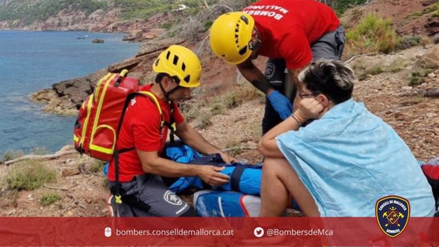 Efectivos de Bomberos de Mallorca atienden a la mujer accidentada.