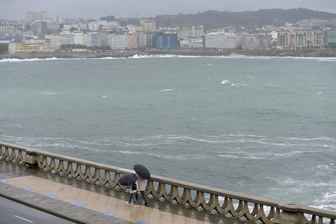 Dos personas con paraguas caminan por el Paseo Marítimo de La Coruña, a 19 de junio de 2022, en A Coruña, Galicia, (España). 