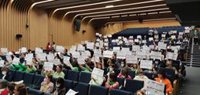 Orientadores educativos levantan pancartas a favor de este servicio público en un acto con cargos de la Consejería