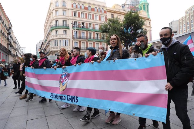 Archivo - Varias personas sostienen una pancarta con el logo de la Plataforma Trans