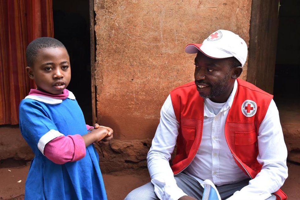 Un trabajador humanitario con una menor desplazada por el conflicto separatista en Camerún