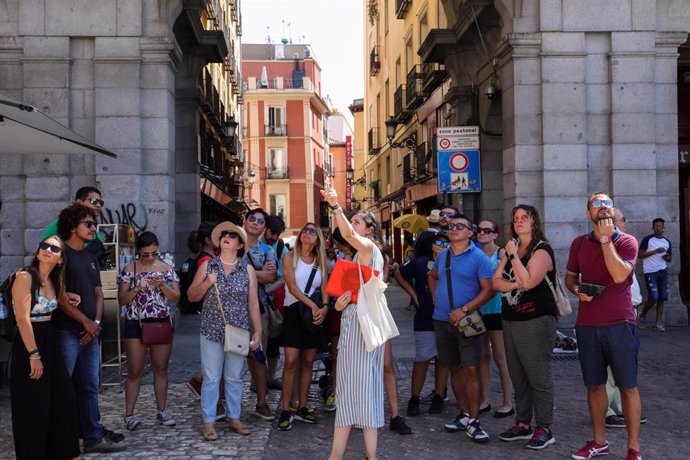 Archivo - Varios turistas se fotografían en una de las calles cercanas a la Plaza Mayor de Madrid.