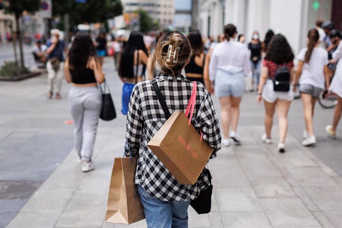 Una mujer pasea con bolsas por la Gran Vía, a 21 de junio de 2022, en Madrid (España)