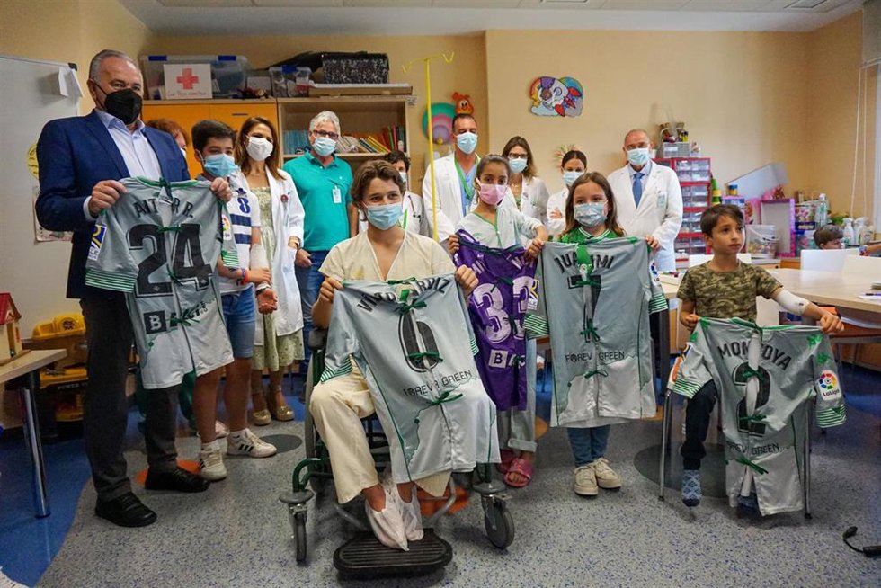 Entrega de camisetas convertidas en batas en el Macarena por el presidente de la Fundación Real Betis Balompié, Rafael Gordillo.