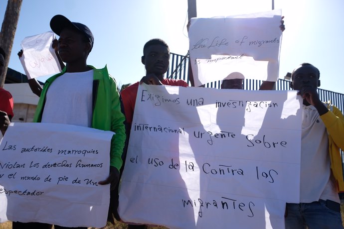 Un grupo de migrantes de origen subsahariano con carteles, durante una concentración en las inmediaciones del CETI para protestar por los hechos ocurridos el pasado 24 de junio en Melilla