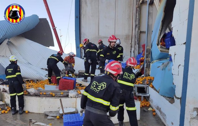 Efectivos de bomberos trabajan tras derrumbarse un depósito en una fábrica de la Pobla de Farnals (Valencia)