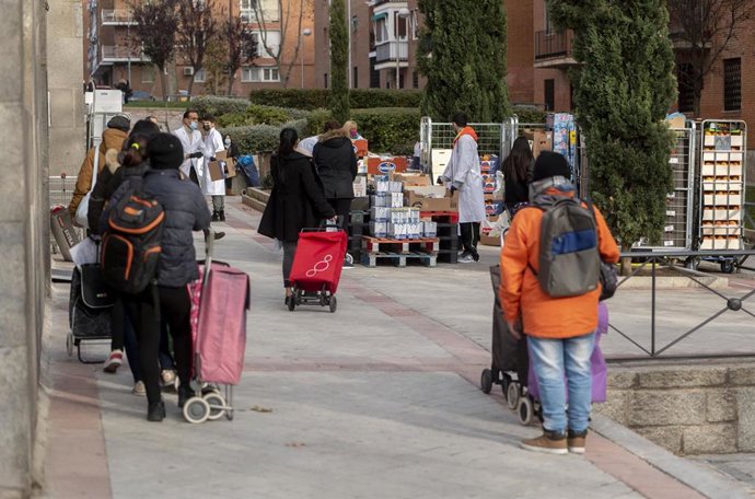 Archivo - Varias personas hacen cola para recibir alimentos de la Fundación Madrina, a 29 de diciembre de 2021, en Madrid, (España). Esta es una de las donaciones a colectivos vulnerables que está llevando a cabo la Fundación Madrina en Navidad, como un