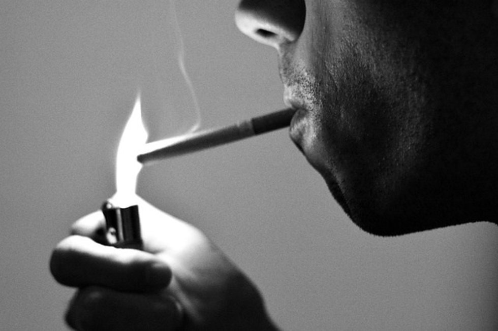 Archivo - Encendiendo un cigarrillo.