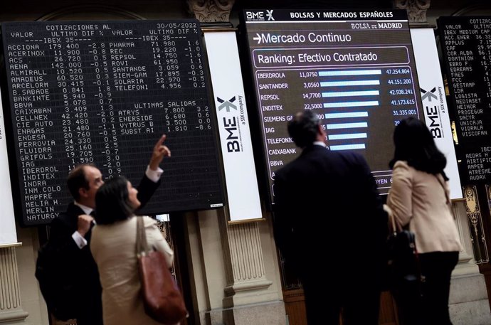 Archivo - Cuatro personas frente a un panel de valores del Ibex 25 en el Palacio de la Bolsa, a 30 de mayo de 2022, en Madrid (España). 