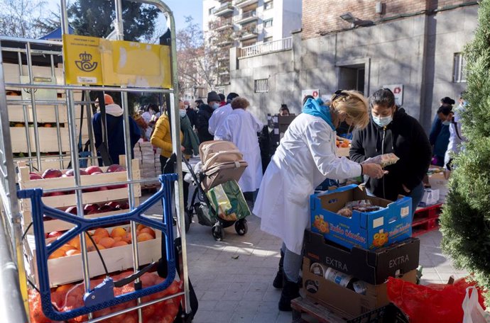 Archivo - Una voluntaria entrega alimentos  a personas vulnerables, foto de recurso