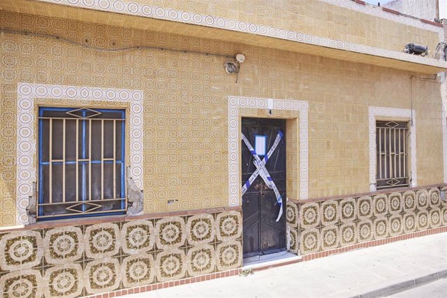 Detalle de la puerta precintada de la vivienda de la calle Fornet Domínguez, de la localidad sevillana de Dos Hermanas, donde se encontraron los dos cadáveres.